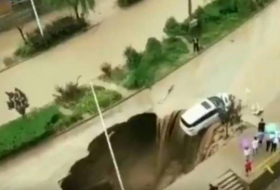 VIDEO: Las lluvias forman un agujero en una carretera y esta casi 'se traga' un coche